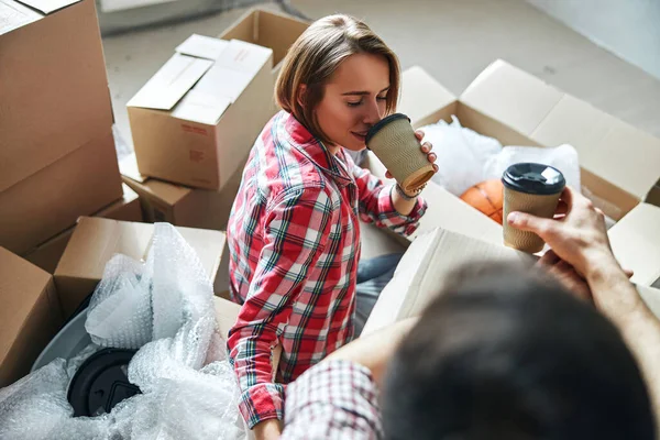 Coppia con bicchieri di carta usa e getta seduti sul pavimento — Foto Stock