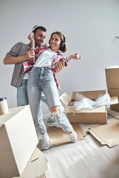 Radostná žena a její manžel tančí ve svém novém bytě — Stock fotografie