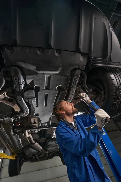 À la station-service mâle travaillant et réparant la voiture — Photo