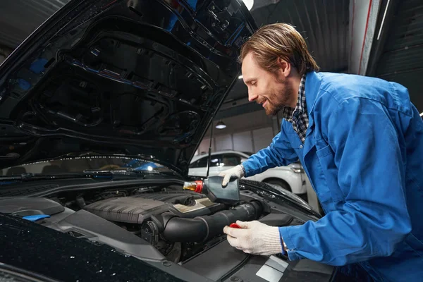 Mechanik provádějící údržbu automobilů na čerpací stanici — Stock fotografie