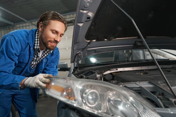 Masculino realiza diagnósticos de óptica de carro na oficina — Fotografia de Stock