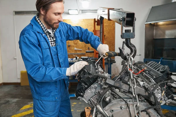 El hombre está inspeccionando el detalle automático durante la reparación —  Fotos de Stock