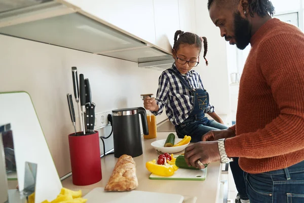 Продумана маленька дівчинка допомагає батькові на кухні — стокове фото