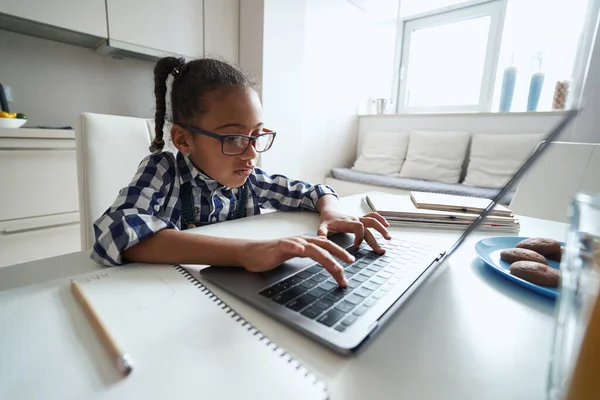 Small girl concentrating on using the keyboard on laptop — Stock Photo, Image