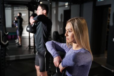 Spor salonunda egzersiz yapan kadın ve erkeğin yakın plan fotoğrafı.