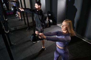 Güçlü bayan ve erkek spor salonunda egzersiz yapıyor.
