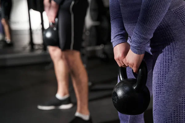 Foto de primer plano de la mujer y el hombre haciendo ejercicio en el gimnasio — Foto de Stock