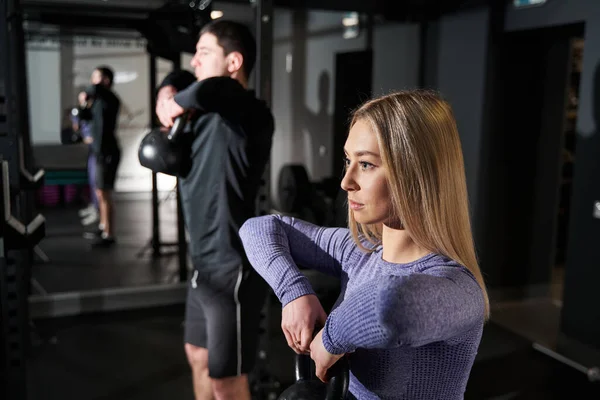 Spor salonunda egzersiz yapan kadın ve erkeğin yakın plan fotoğrafı.