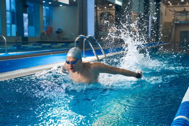 Antrenman sırasında havuzda yüzen güçlü adam.