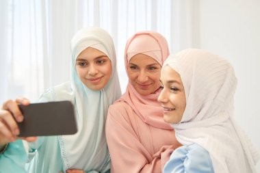 Mutlu Müslüman kadın akrabalarıyla selfie çekiyor.