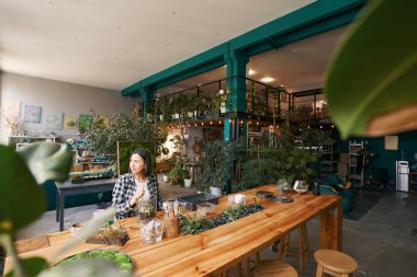 Stüdyoda çalışan ve pencereye bakan bir kadın.