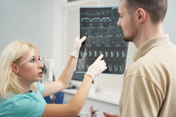 Női orvos mutatja gerinc röntgen a fiatal férfi — Stock Fotó