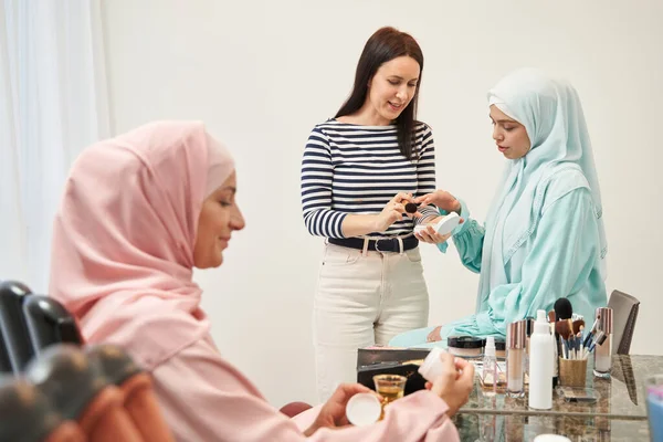 Vážná mladá muslimka vybírá vhodnou kosmetiku — Stock fotografie