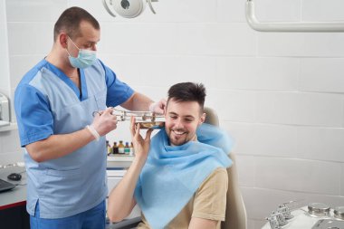 otorhinolaryngolojistin ameliyatları sırasında neşeli genç adam.