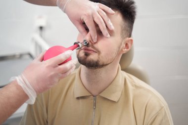 Doktor klinikteki hastaların burun kıllarını duruluyor.