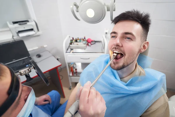 Усміхнений чоловік з болем в горлі відвідує оториноларинголога — стокове фото