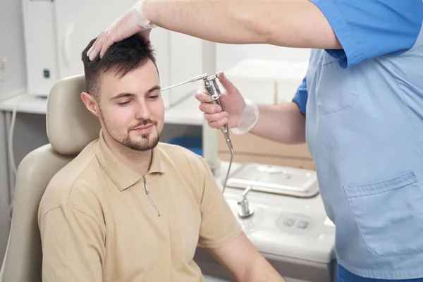 Молодий чоловік відвідує лікаря для лікування вух — стокове фото