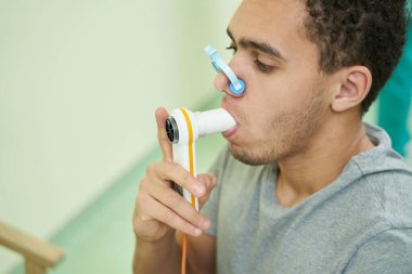 Hasta akciğer fonksiyonlarını spirometreyle kontrol ediyor.