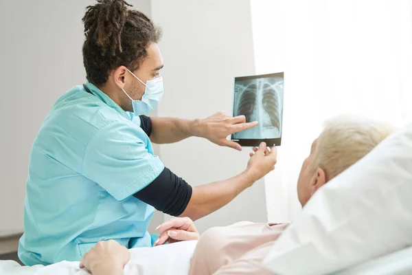 Trabajador médico señalando un problema en radiografía de rayos X — Foto de Stock