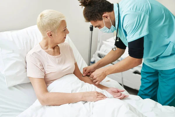 Médico que lleva a cabo terapia intravenosa a ancianos — Foto de Stock