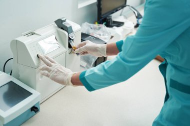 Kadın kan örneklerini modern ekipmanlarla analiz ediyor.