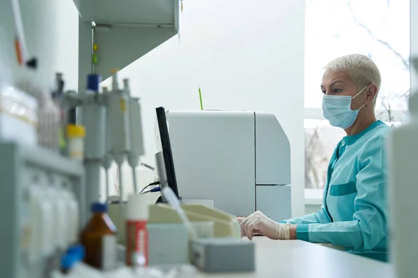 Mature woman working with pc in laboratory — Stock fotografie