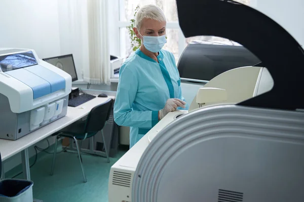 Kobieta robi badania medyczne z nowoczesnymi maszynami — Zdjęcie stockowe