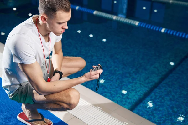 Athletic man looking at the timer in his hand — Foto Stock