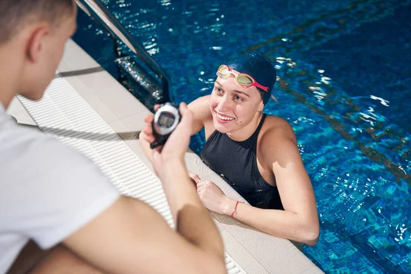 Mujer sonriente nadadora está escuchando consejos entrenador — Foto de Stock
