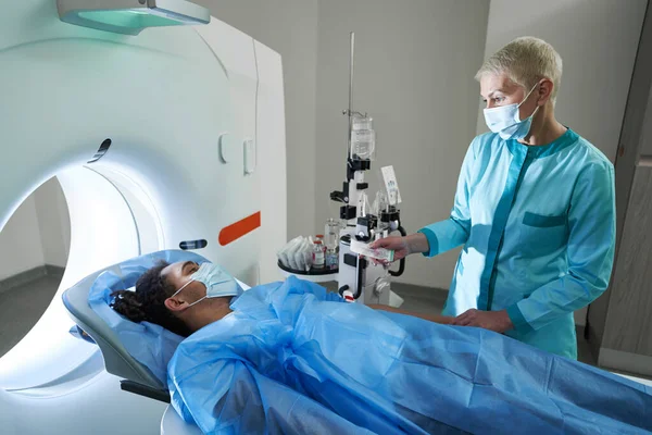 Kadın doktor erkeği ve ekipmanları spektroskopi için hazırlıyor.