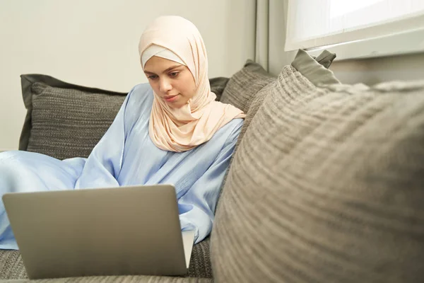 Mulher muçulmana trabalhando em notebook em casa — Fotografia de Stock