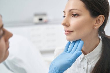 Kadın kozmetoloji kliniğinde cilt muayenesi yaptırıyor.