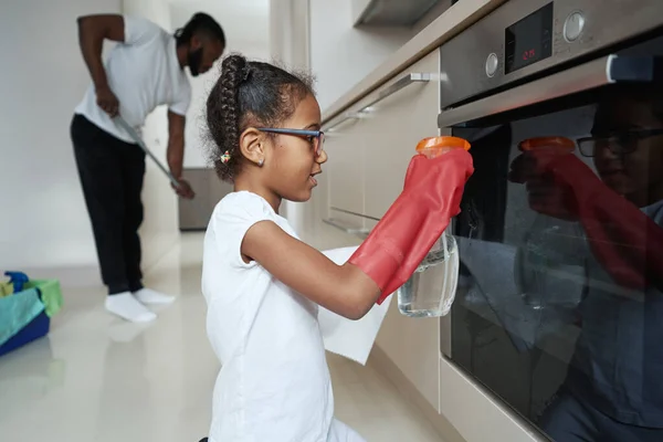 Piccola ragazza afro-americana porta del forno di lavaggio accanto al padre — Foto Stock