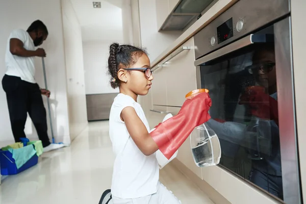 Little girl is washing stove next to father in kitchen — 图库照片