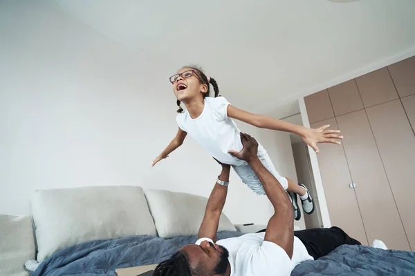 Adulti afro-americani uomo sta tenendo la figlia sopra di lui — Foto Stock