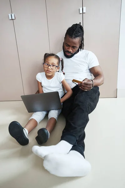 Daughter with father use laptop on the floor in room — Stock Photo, Image