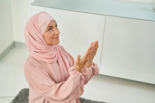 Smiling young Muslim woman praying glorifying God at home — 스톡 사진