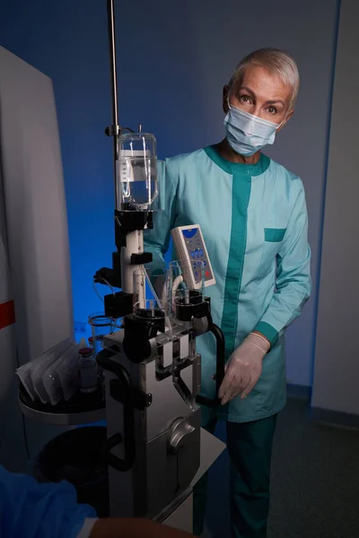 Female doctor using modern medical equipment with dropper — Stock fotografie