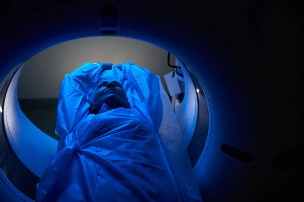 Smiling mature woman during MRI procedure in dark office — Stock fotografie