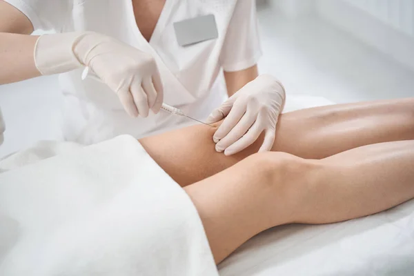 Médico manos haciendo inyección en mujer pierna —  Fotos de Stock