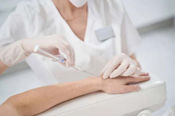 Mujer recibiendo rejuvenecimiento brazo inyección en clínica de belleza —  Fotos de Stock