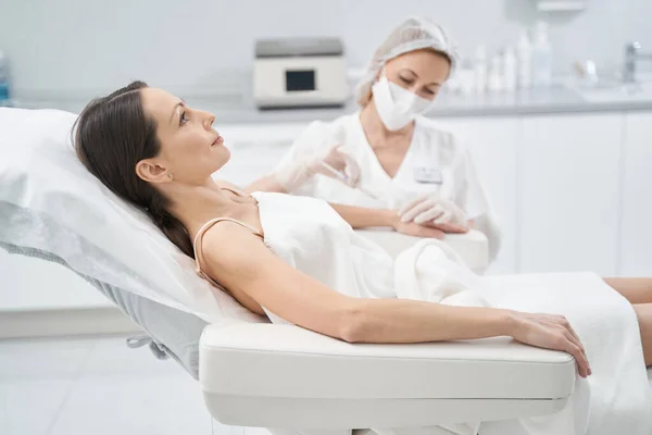 Mulher recebendo tratamento por injeção de braço na clínica de beleza — Fotografia de Stock