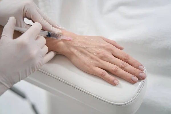 Mujer recibiendo inyección de rejuvenecimiento de la mano en salón de belleza —  Fotos de Stock