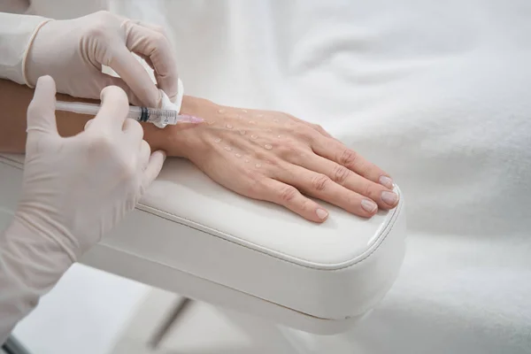 Médico cosmetólogo haciendo inyección en la mano femenina —  Fotos de Stock