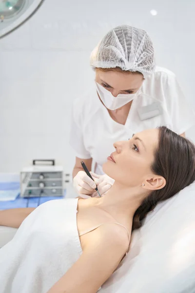 Doctor performing laser mole removal procedure in beauty center — Photo