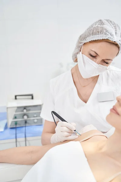 Woman having laser skincare procedure in beauty salon — Photo