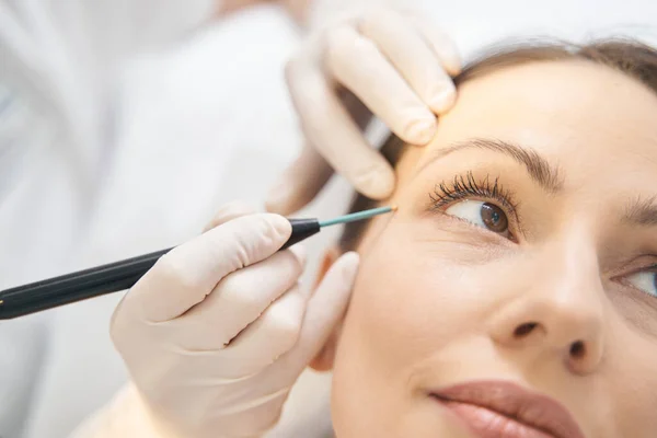 Vrouw ontvangt gezichtsverzorging in schoonheidssalon — Stockfoto
