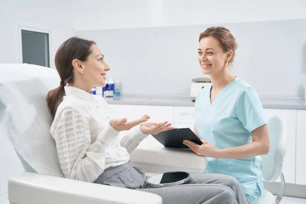 Vrouw in overleg met cosmetoloog in schoonheidskliniek — Stockfoto