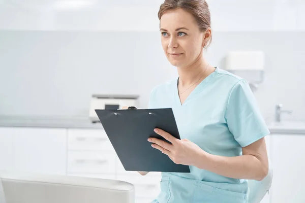 Female doctor writing on clipboard in cosmetology clinic — Foto Stock