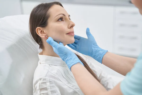 Arts schoonheidsspecialiste controleren vrouw gezicht huid in cosmetologie kliniek — Stockfoto